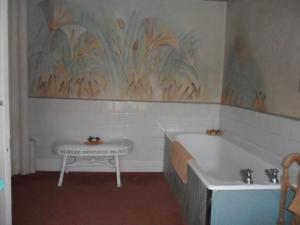 
a bathroom with a tub, sink, and toilet at Stanshope Hall in Alstonfield
