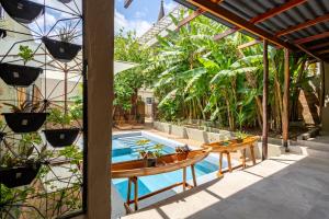 an outdoor patio with a pool and tables and plants at Hotel Casa do Bispo in Manaus