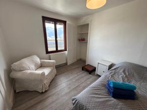 1 dormitorio con 1 cama, 1 silla y 1 ventana en Logements Gare Brignoud, en Villard-Bonnot