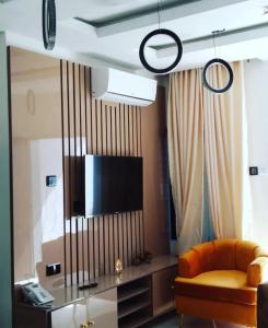 a living room with a couch and a flat screen tv at Supreme Apartments in Ibadan