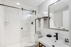 uma casa de banho com um WC, um lavatório e um espelho. em Cape Suites Room 5 -Free Parking! Hotel Room em Rehoboth Beach