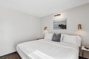 a bedroom with a bed with white sheets and pillows at Cape Suites Room 5 -Free Parking! Hotel Room in Rehoboth Beach