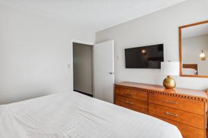 1 dormitorio con 1 cama y vestidor con espejo en Cape Suites Room 8 - Free Parking! Hotel Room, en Rehoboth Beach