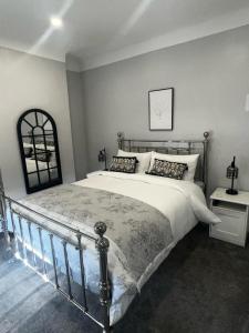 a bedroom with a large bed with a metal frame at Quay Cottage in Parkgate