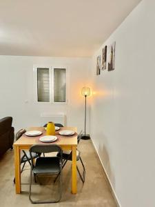 een tafel en stoelen in een woonkamer met een tafel en een lamp bij Cosy Appartement Noisy-le-Sec in Noisy-le-Sec