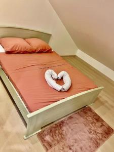 twee handdoeken in de vorm van een hart op een bed bij Cosy Appartement Noisy-le-Sec in Noisy-le-Sec