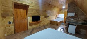 a wooden room with a television and a room with at Chale com hidromassagem da Vick in Campos do Jordão