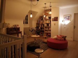 a living room with a red ottoman and a staircase at Maison et Florescence in Nuits-Saint-Georges