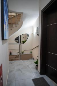 a hallway with a spiral staircase and a mirror at Theo and Irin's Houses in Flogita