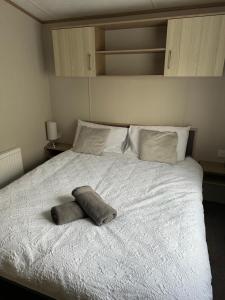 a bed with a pillow on top of it at 2 Bedroom Lakeview Lodge - Ensuite & Balcony Deck in Carnforth