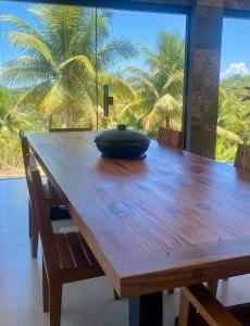 a wooden table with a bowl on top of it at La Maison Loosaï -Σlégance-avec TV in Itacaré