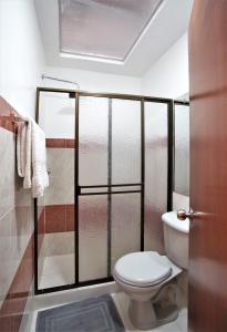 La salle de bains est pourvue d'une douche et de toilettes. dans l'établissement Casa Blanca Hospedaje, à Pasto