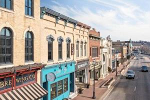 Hip Urban Loft - Small Town Charm - 124 LOFTS #1 في West Dundee: شارع المدينة فيه مباني وسيارات على الطريق