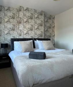 um quarto com uma cama grande e lençóis brancos em Charming 2-BR Property - Sleeps 5 em Warrington