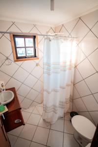 uma casa de banho com uma cortina de chuveiro e um lavatório em Alameda Galu em Atibaia