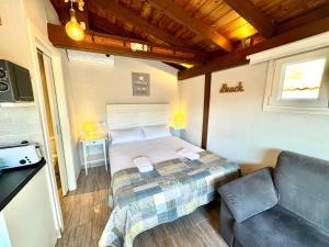 a small bedroom with a bed and a couch at 3 Casita-Estudio con Jardín en la playa in Puerto Marino