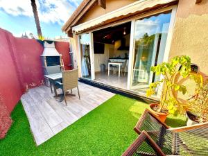 a patio with a table and chairs and a fireplace at 3 Casita-Estudio con Jardín en la playa in Puerto Marino