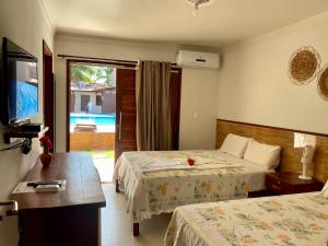 聖米格爾－杜斯米拉格里斯的住宿－Pousada Paraíso dos Milagres，酒店客房设有两张床和电视。