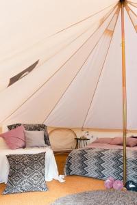 Glamping in Småland في إيكشو: غرفة نوم بسريرين في خيمة
