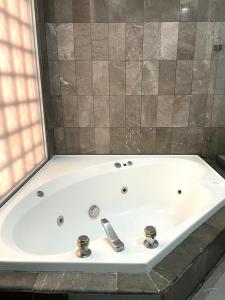 une grande baignoire blanche avec deux robinets dans l'établissement Hotel Arroyo de la Plata, à Zacatecas