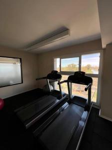 a gym with two treadmills in a room with a window at Apart de categoría con amenities y estacionamiento in Buenos Aires