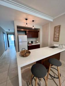 a kitchen with a counter and two bar stools at Apart de categoría con amenities y estacionamiento in Buenos Aires