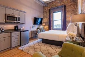 a hotel room with a bed and a kitchen with a kitchen at Hip Urban Loft - Small Town Charm -124 LOFTS #3 in West Dundee