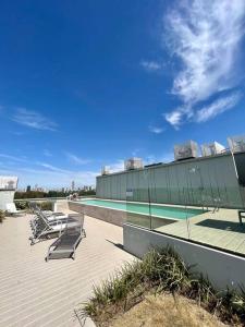 uma piscina com espreguiçadeiras ao lado de um edifício em Apart de categoría con amenities y estacionamiento em Buenos Aires