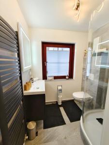ein Bad mit einem Waschbecken, einem WC und einem Fenster in der Unterkunft Apartment Artista in Weitensfeld