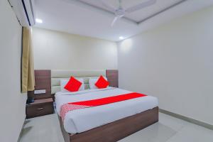 een slaapkamer met een bed met rode kussens bij Collection O Greenwood in Ahmedabad