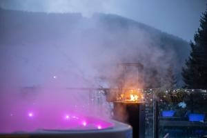 a person is holding a candle in a pot with smoke at Pytloun Wellness Hotel Harrachov in Harrachov