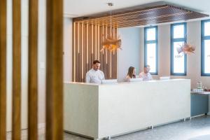 a group of people sitting at a reception desk at Hotel Málaga Vibes in Málaga