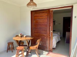 Pousada Paraíso dos Milagres في ساو ميغيل دوس ميلاجريس: طاولة وكراسي في غرفة مع غرفة نوم