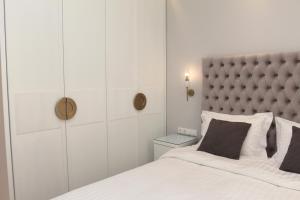 a bedroom with a large bed with a padded headboard at central metropolis luxury living in Athens