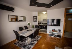 Apartman Elly في سلافونسكي برود: مطبخ وغرفة طعام مع طاولة وكراسي