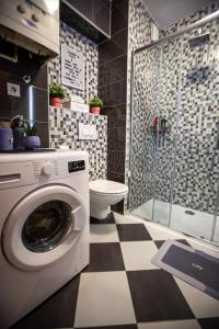 een badkamer met een wasmachine en een toilet bij Apartman Elly in Slavonski Brod