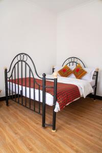 Una cama negra con almohadas rojas a cuadros. en New Dream House, en Arusha