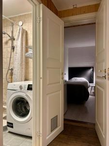 a washer and dryer in a bathroom with a bedroom at Simple room in Trondheim