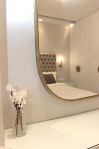 a vase with flowers on a counter in front of a mirror at central metropolis luxury living in Athens