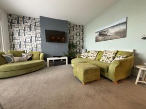 sala de estar con 2 sofás y TV en SeaScape, en Bexhill-on-Sea
