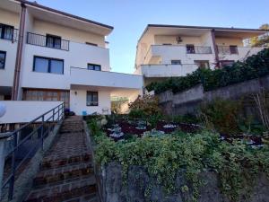 un edificio de apartamentos con jardín frente a él en La Casa Veneta - Hostel, en Muggia