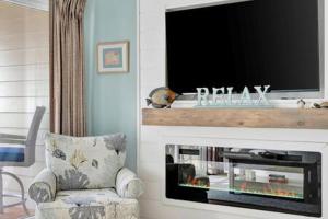 a living room with a flat screen tv and a chair at Oceans Pointe Nantucket inspired condo on the bay in Tampa