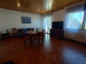 comedor con mesa, sillas y TV en La Casa Veneta - Hostel, en Muggia