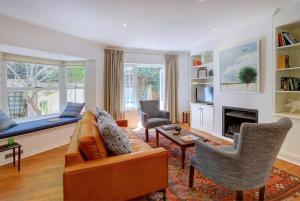 a living room with a couch and a fireplace at Sunbird Cottage - Wilderness in Wilderness