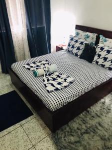 a bed with black and white sheets and pillows at HAVRE DE CHARME A YAOUNDE in Yaoundé
