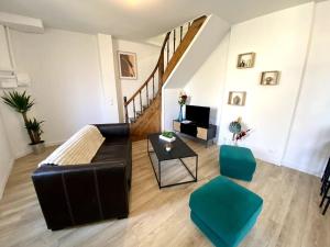 - un salon avec un canapé, des chaises et un escalier dans l'établissement Appartement 2chambres/PuyDuFou, à Mauléon