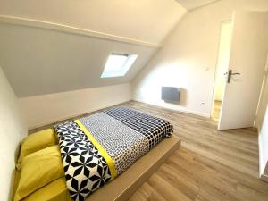 Un dormitorio con una cama en una habitación con ventana. en Appartement 2chambres/PuyDuFou, en Mauléon