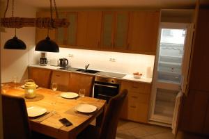 a kitchen with a wooden table with chairs and a dining room at Ferienwohnung Pobershau in Pobershau