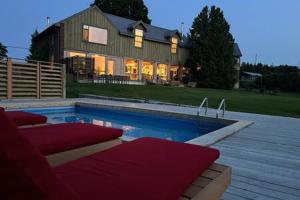 a large house with a swimming pool in front of it at Away in the County-Sandbanks Pec in Cherry Valley