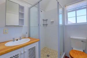 a white bathroom with a sink and a shower at Sunbird Cottage - Wilderness in Wilderness +26 photos